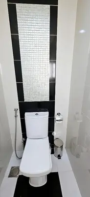 a white toilet in a bathroom with black and white tiles at Superb 1 BR apt next to Burj Khalifa and Dubai mall in Dubai