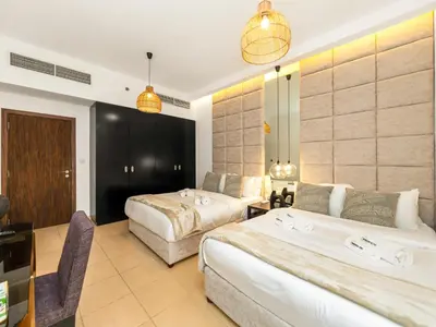 a hotel room with two beds and a desk at WonderfulStay At JBR - Luxury Dubai Eye View Living - Beach Access - Brand New Luxury Apartments in Dubai