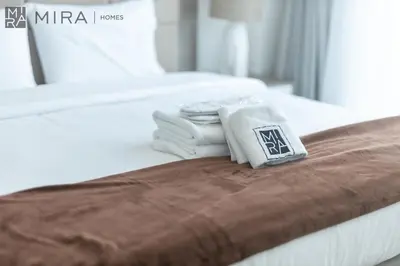 a pile of towels sitting on top of a bed at Mira Holiday Homes - Cosy 1 bedroom close to metro Al Furjan in Dubai