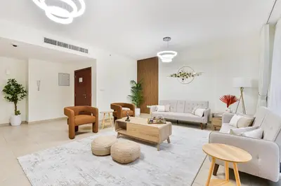 a living room with couches and a table at Savis Home Oceanfront Serenity and Marina Views in Dubai