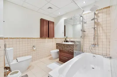 a bathroom with a tub and a toilet and a sink at Savis Home Oceanfront Serenity and Marina Views in Dubai