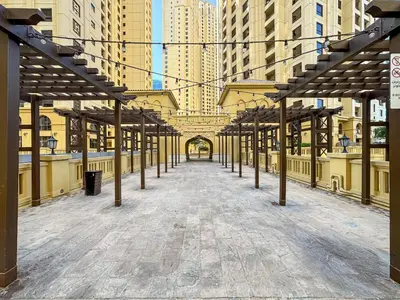 an empty walkway in a city with tall buildings at Savis Home Oceanfront Serenity and Marina Views in Dubai