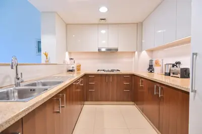 a kitchen with wooden cabinets and a sink at Burj Vista 2BR Luxurious Apartment with Direct Access to Dubai Mall in Dubai