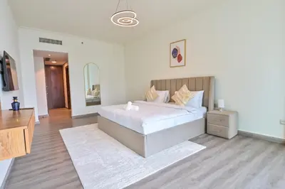 a bedroom with a large white bed and a dresser at Burj Vista 2BR Luxurious Apartment with Direct Access to Dubai Mall in Dubai