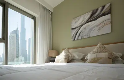 a bedroom with a white bed with a large window at Apartment in Downtown Dubai in Dubai