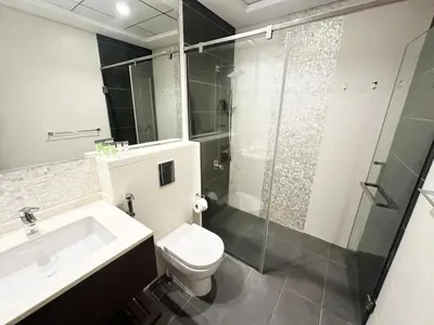 a bathroom with a toilet and a sink and a shower at Meydan Marvel Sleek 1-Bedroom Home in Prime Views with Luxe Finishes! by Petals Holiday Homes in Dubai