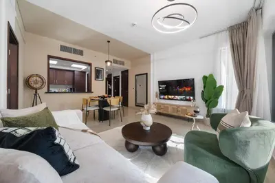 a living room with a couch and a tv at The Boulevard Suite Luxury Burj Khalifa View - Downtown in Dubai