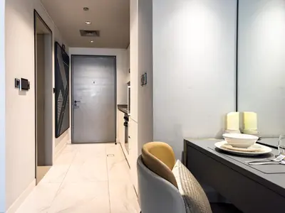 a hallway with a desk and a chair and a door at Select Stay-Studio in MAG 318 - Minutes to Dubai Mall in Dubai