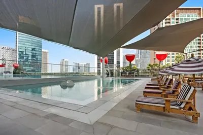 a pool with chairs and umbrellas in a building at Select Stay-Studio in MAG 318 - Minutes to Dubai Mall in Dubai