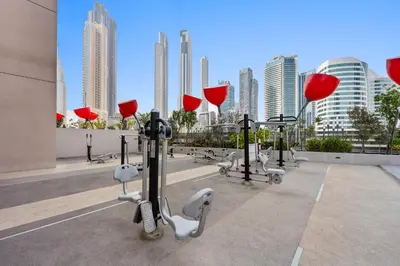 a row of exercise equipment on a building with tall buildings at Select Stay-Studio in MAG 318 - Minutes to Dubai Mall in Dubai