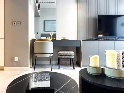 a living room with a table and a tv at Select Stay-Studio in MAG 318 - Minutes to Dubai Mall in Dubai