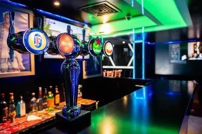 a bar with a row of lights on a counter at Manhattan Avenue Hotel in Dubai