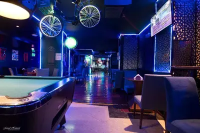 a bar with a pool table and bikes on the ceiling at Manhattan Avenue Hotel in Dubai