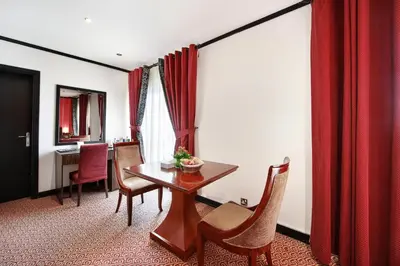 a dining room with a wooden table and chairs at Manhattan Avenue Hotel in Dubai