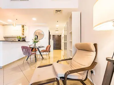 a living room with a chair and a table at Luxury Modern 1BR-Concorde Tower 1-JLT in Dubai