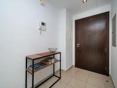 a hallway with a door and a shelf with books at Bright 1-Bedroom with Marina Infinity Pool in Dubai