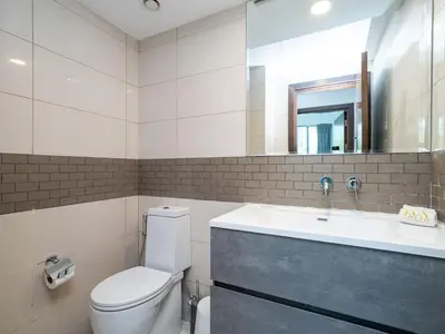 a bathroom with a toilet and a sink and a mirror at Bright 1-Bedroom with Marina Infinity Pool in Dubai