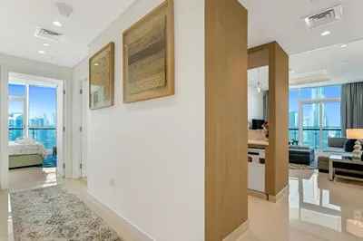 a living room with white walls and a large window at 2 Bedrooms with Iconic Burj Khalifa Views Stay in Dubai