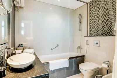 a bathroom with a sink and a toilet and a tub at 2 Bedrooms with Iconic Burj Khalifa Views Stay in Dubai