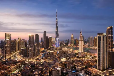 a city skyline at night with a tall skyscraper at 2 Bedrooms with Iconic Burj Khalifa Views Stay in Dubai