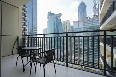 a balcony with a table and chairs and a view of the city at Luxurious Pool View 1BHK, Zada Tower in Dubai
