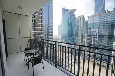 a balcony with two chairs and a table on a building at Luxurious Pool View 1BHK, Zada Tower in Dubai