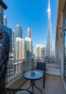 a balcony with a table and chairs and a view of a city at Luxurious one bedroom Apartment with Burj Khalifa View in Dubai