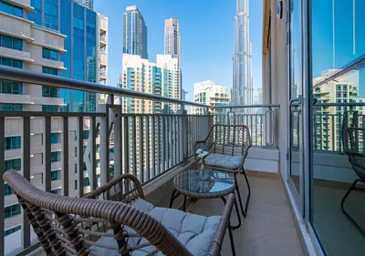 a balcony with two chairs and a table with a view of a city at Luxurious one bedroom Apartment with Burj Khalifa View in Dubai