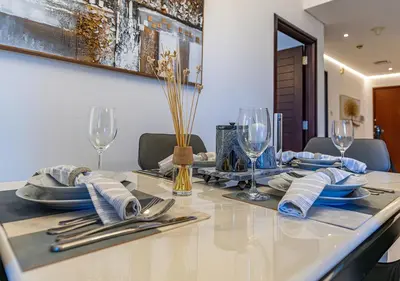 a table with plates and napkins and wine glasses at Luxurious one bedroom Apartment with Burj Khalifa View in Dubai