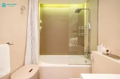 a bathroom with a toilet and a glass shower at Blue Breeze - Modern Apt with Partial Marina Views & Balcony in Dubai