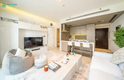 a living room with a couch and a table at Blue Breeze - Modern Apt with Partial Marina Views & Balcony in Dubai