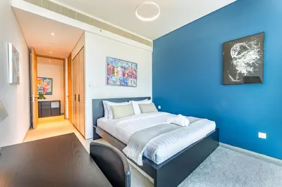 a blue bedroom with a bed and a couch at Luxury 2 Bedroom Apartment with Breathtaking Dubai in Dubai