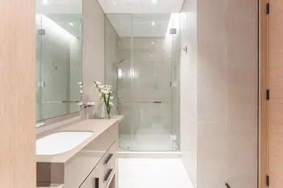 a bathroom with a shower and a sink and a mirror at Luxury 2 Bedroom Apartment with Breathtaking Dubai in Dubai
