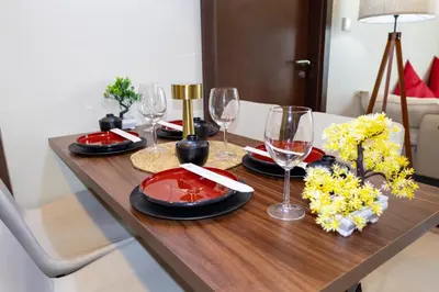a wooden table with wine glasses and flowers on it at japanDXB Burj Khalifa view - 4min Dubai Mall in Dubai