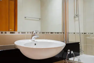a white sink in a bathroom with a shower at SettlerHomes - FIRST CLASS JBR Stay On High-Floor in Dubai