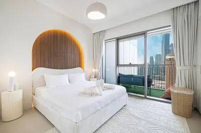 a bedroom with a large white bed and a large window at Full Burj view & Direct Access to Dubai Mall in Dubai