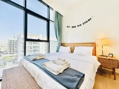 a bed with towels on it in a room with a window at Chic 1-BR in Azizi Riviera-Your Perfect Stay ! in Dubai