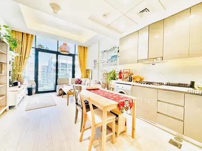 a kitchen and living room with a table and chairs at Chic 1-BR in Azizi Riviera-Your Perfect Stay ! in Dubai