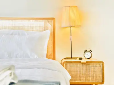a bed with a lamp and a clock on a side table at Chic 1-BR in Azizi Riviera-Your Perfect Stay ! in Dubai