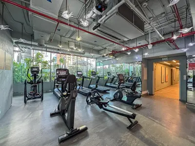 a gym with several treadmills and elliptical machines at Upmarket Studio in Business Bay with a Gym and Pool in Dubai