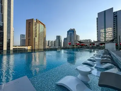 a large swimming pool with a city skyline in the background at Upmarket Studio in Business Bay with a Gym and Pool in Dubai
