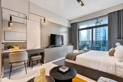 a hotel room with a bed and a desk and a tv at Upmarket Studio in Business Bay with a Gym and Pool in Dubai