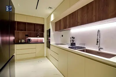 a kitchen with wooden cabinets and a sink at Luxury Escapes - Three-Bedroom Apartment with Lake View in Dubai