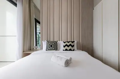 a large white bed with two rolled towels on it at Waves - Modern Apt with Balcony & Canal View in Business Bay in Dubai