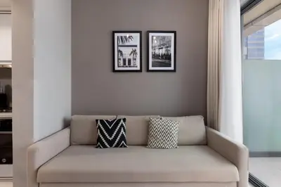 a couch in a living room with two pictures on the wall at Waves - Modern Apt with Balcony & Canal View in Business Bay in Dubai