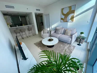 a living room with a couch and a table at Great one bedroom apartment with infinity pool in Dubai