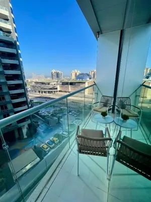 a balcony with two chairs and a table on a building at Great one bedroom apartment with infinity pool in Dubai