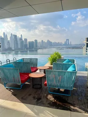 a patio with chairs and tables and a view of the city at Great one bedroom apartment with infinity pool in Dubai