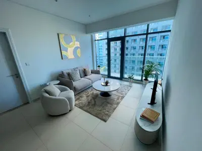 a living room with a couch and a table at Great one bedroom apartment with infinity pool in Dubai
