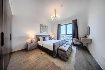 a bedroom with a bed and a couch and a window at New 1 BD in Madinat Jumeirah Living in Dubai